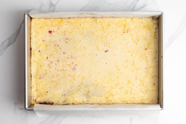 baked lemon cranberry bars, viewed from overhead in a metal pan. The top layer is barely set.