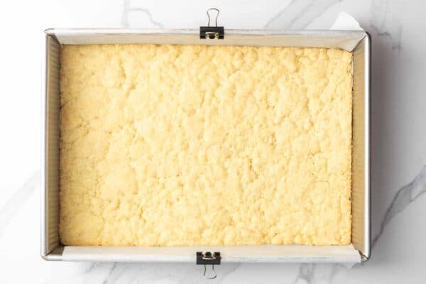 baked crust for lemon bars in a metal baking pan. The edges are lightly browned.