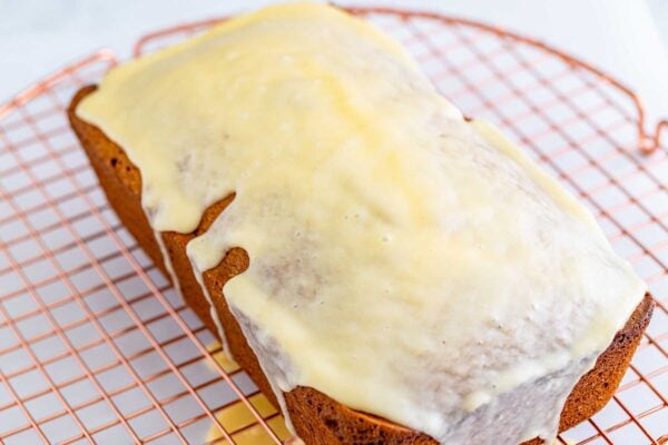 Eggnog loaf glazed with eggnog glaze placed on a wire rack to set