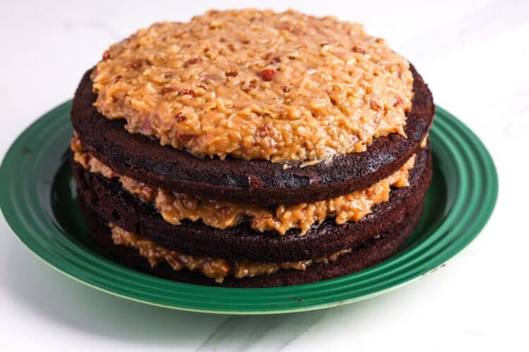 three layers of german chocolate cake with coconut filling in between and on top.
