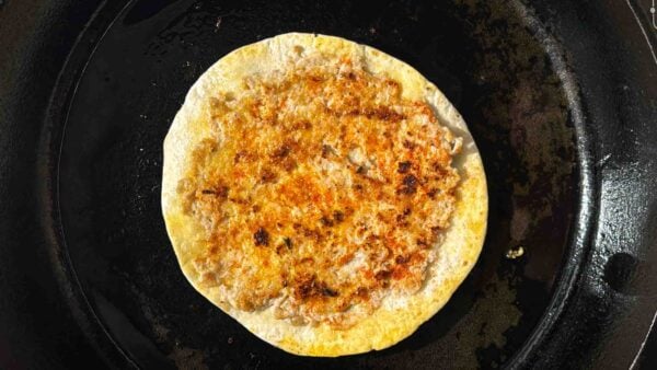 Cooked chicken smash taco in a pan