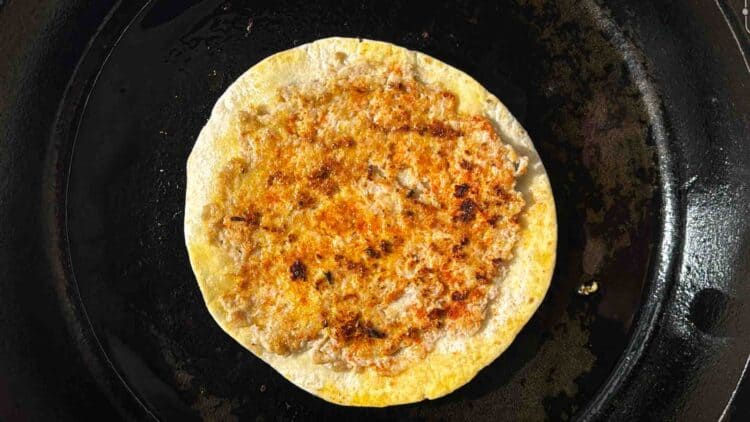 Cooked chicken smash taco in a pan
