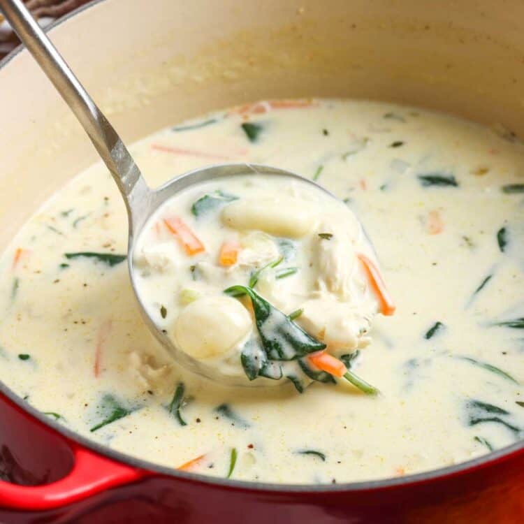 a red dutch oven filled with creamy olive garden inspired chicken gnocchi soup.