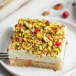 A slice of aish el saraya served on a white dessert plate