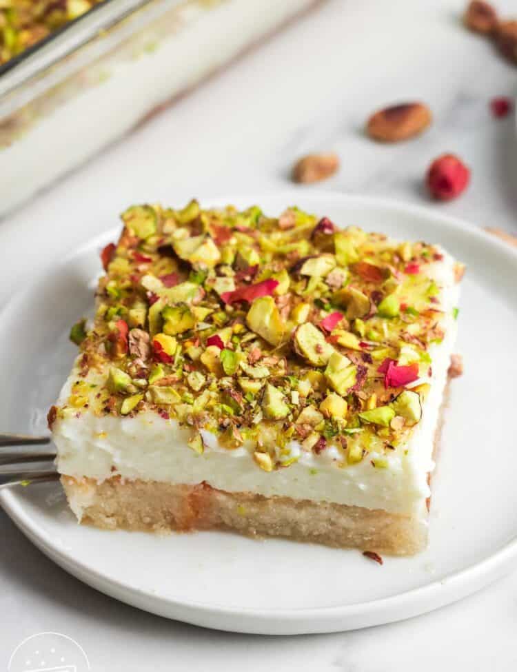 A slice of aish el saraya served on a white dessert plate