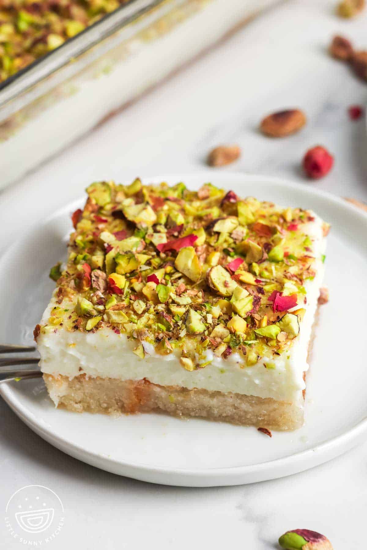 A slice of aish el saraya served on a white dessert plate