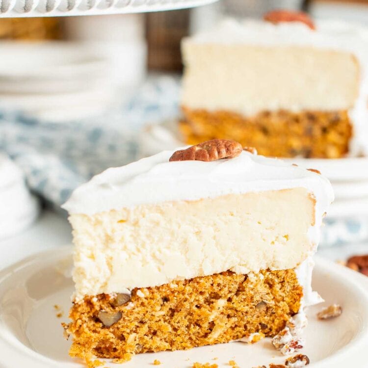 A slice of carrot cake cheesecake on a small white plate.