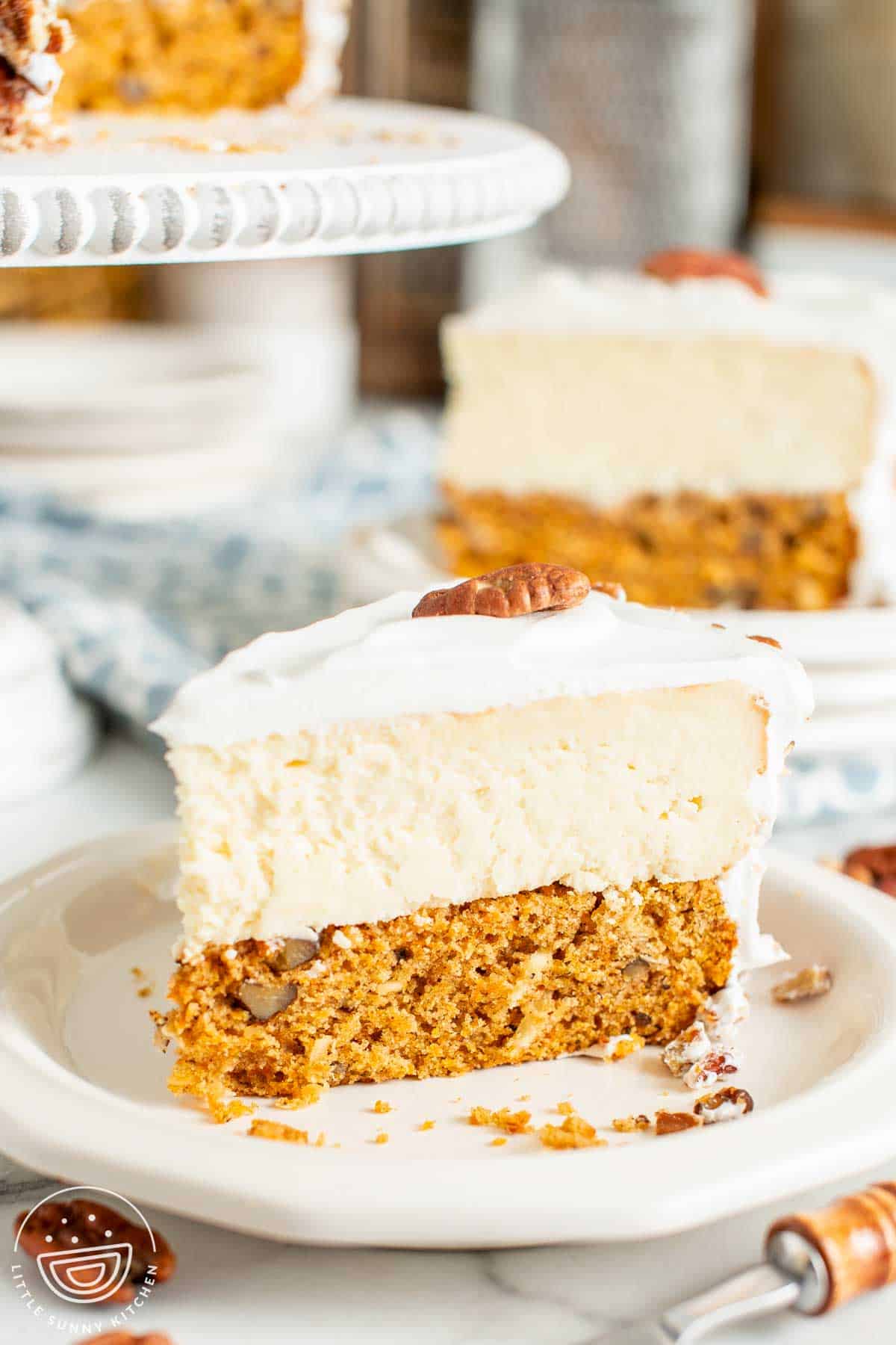 A slice of carrot cake cheesecake on a small white plate.