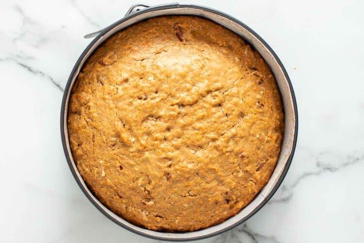 Carrot cake baked in a cheesecake pan, cooling on the counter.