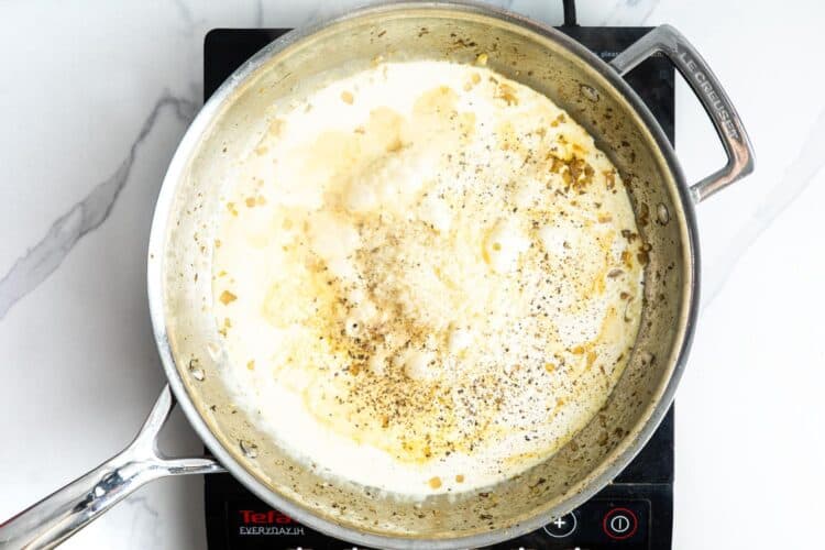 heavy cream added to a skillet with sauteed shallots and garlic.