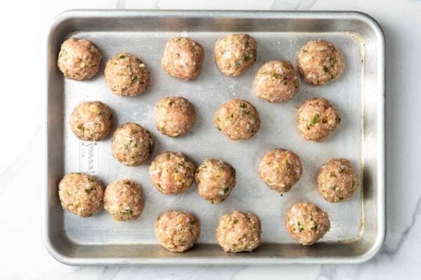 raw lemon chicken meatballs on a small baking sheet.