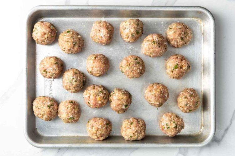 raw lemon chicken meatballs on a small baking sheet.