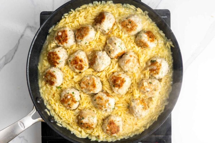 tender orzo cooked with lemon chicken meatballs in a nonstick skillet.