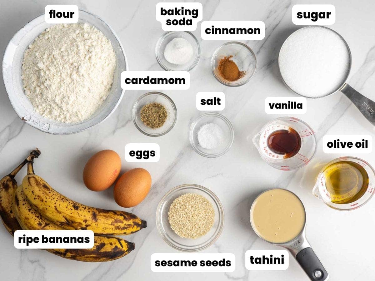 Ingredients for making banana bread with tahini, including cinnamon, cardamom, olive oil, and eggs. The ingredients are measured into small bowls.