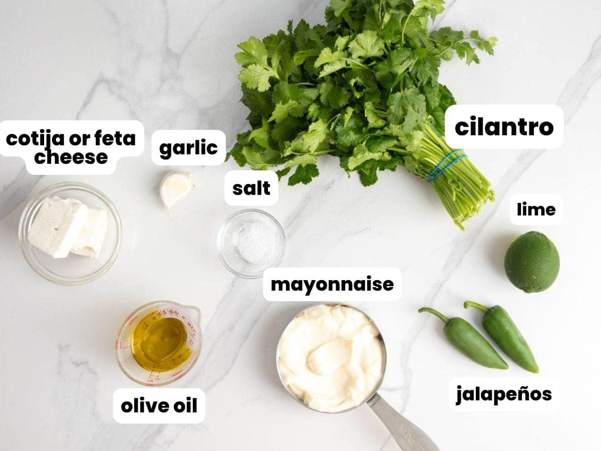 ingredients for Peruvian green sauce (aji verde) including cilantro, jalapeños, garlic, lime, and mayonnaise