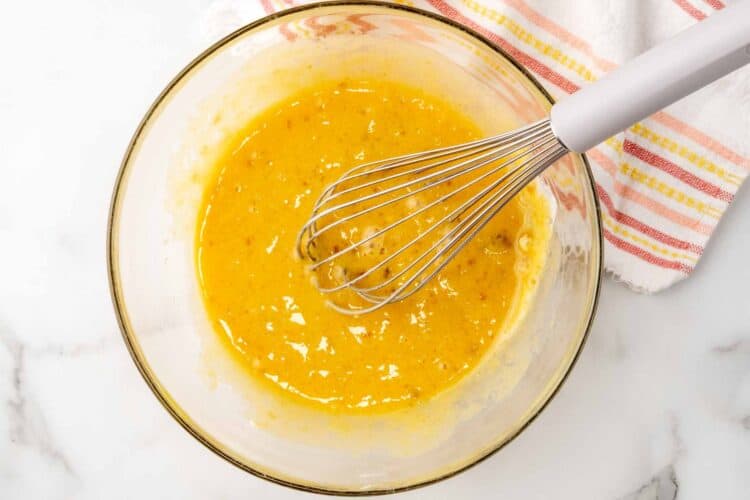 eggs and sugar whisked together in a glass bowl.