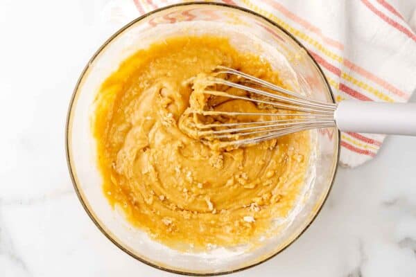 carrot cake cupcake batter in a glass bowl with a whisk.