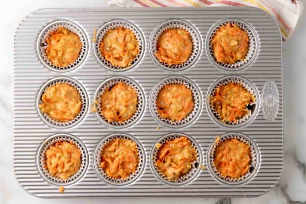 carrot cake cupcake batter portioned into a paper lined cupcake pan.
