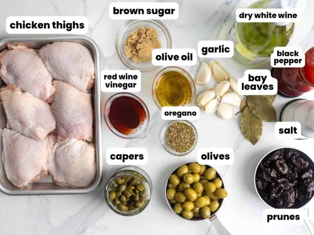 Ingredients for making chicken marbella from Silver palate cookbook, including chicken thighs, sugar, vinegar, white wine, capers, olives, and prunes.