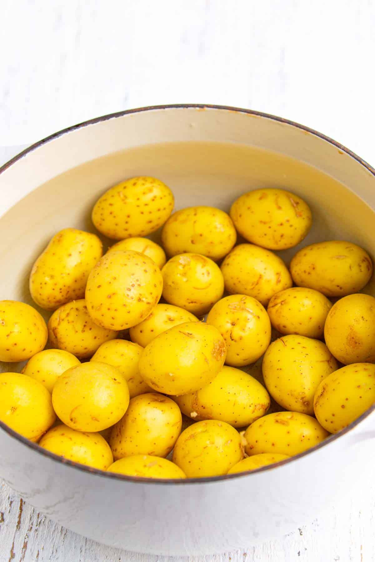 Baby gold potatoes in a pot of water, ready to be boiled for creamy smashed potato salad.