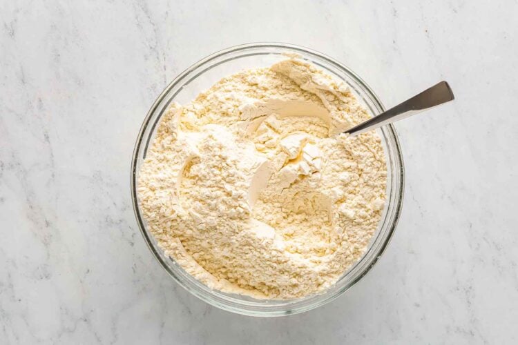 All purpose flour, baking powder, baking soda, and salt mixed together in a glass bowl.