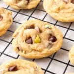 mini egg chocolate chip cookies cooling on a black wire rack.