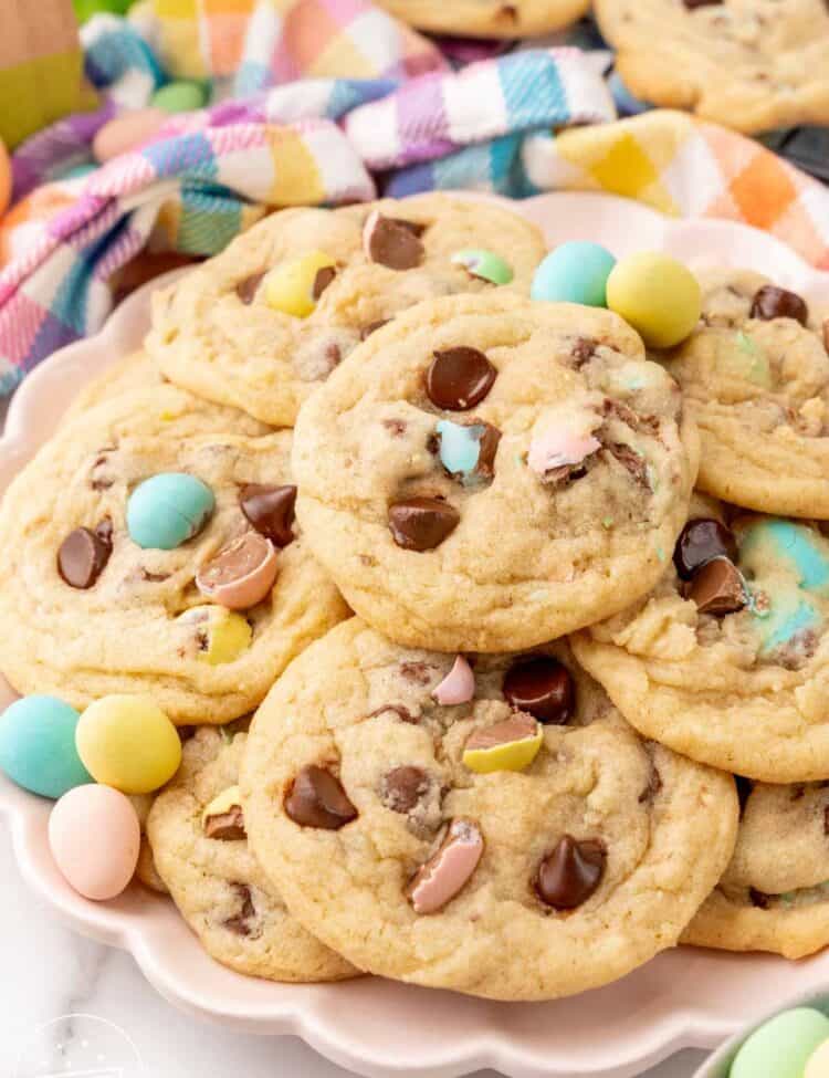 a pink scalloped plate of cadbury mini egg cookies, decorated with extra candy eggs.