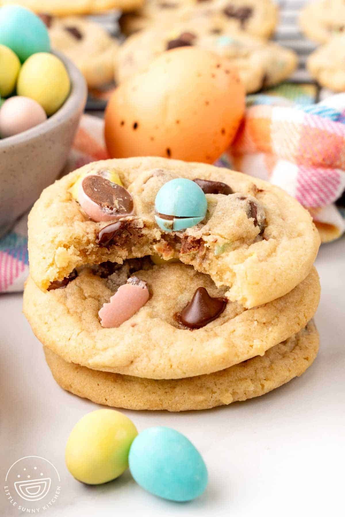 three mini egg cookies, stacked. the top one has a bite taken out