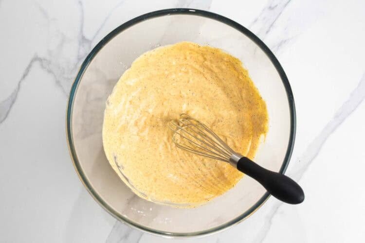 mustard, mayo, garlic, and seasonings whisked together in a glass bowl.
