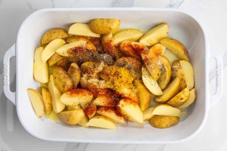 potatoes cut into wedges, in a 9x13 pan with seasonings and melted butter added.