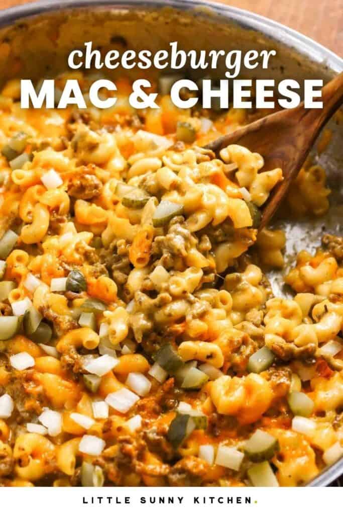 Cheeseburger mac and cheese topped with chopped pickles and onions, in a skillet. Text overlay says "cheeseburger mac and cheese"