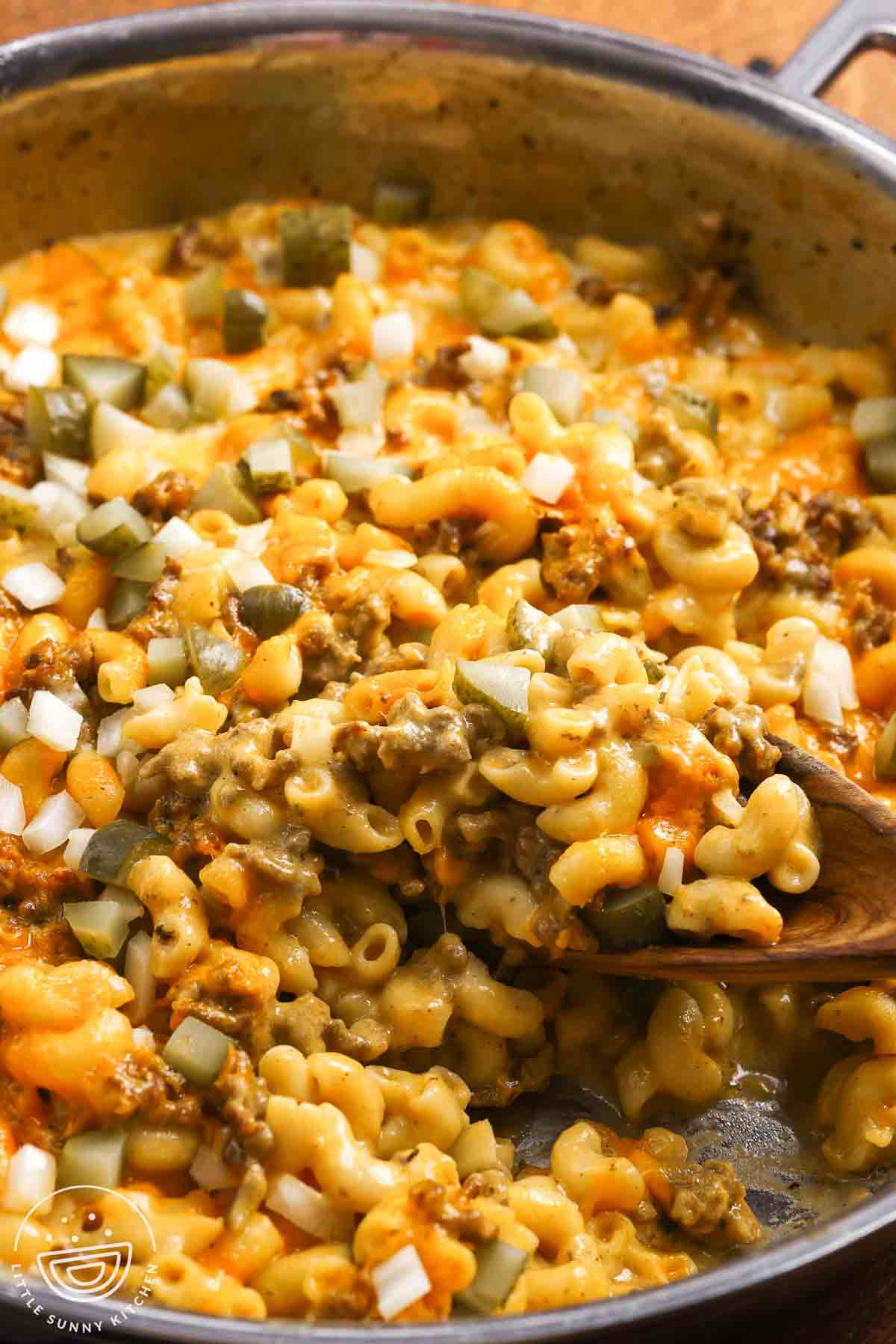 Cheeseburger mac and cheese, finished with chopped dill pickles and chopped raw onion.