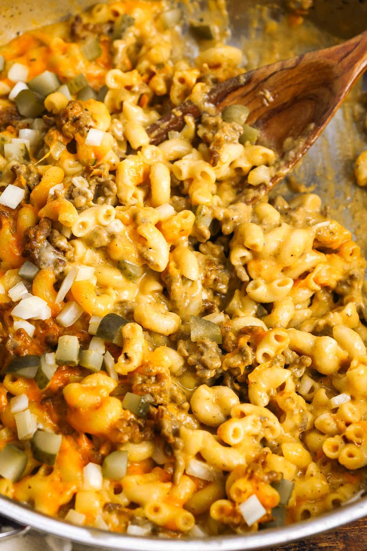 a pan of cheeseburger macaroni and cheese, served with a wooden spoon.