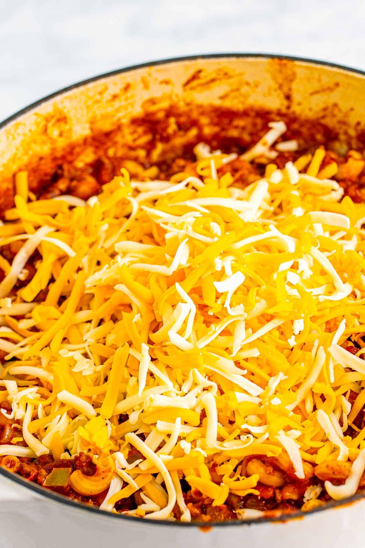 Shredded cheddar and Monterey Jack cheese added on top of chili macaroni.
