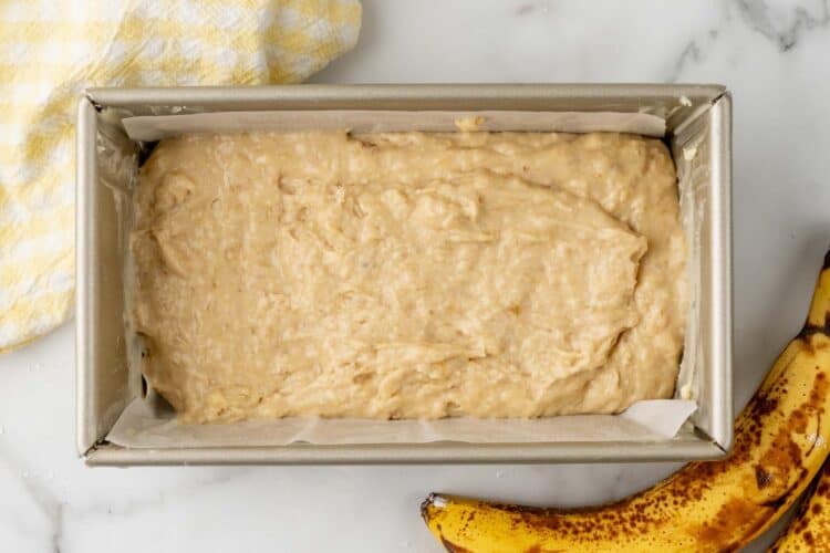 banana bread batter filling a loaf pan halfway.