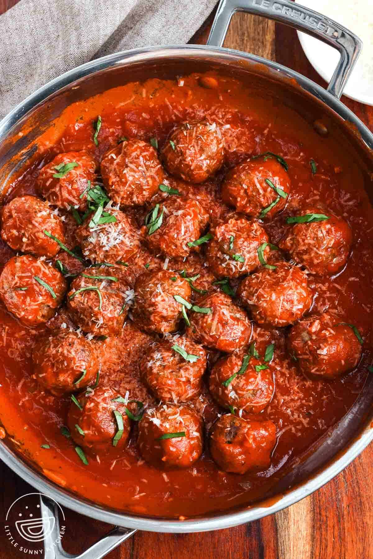 meatballs made with ricotta cheese, finished in a skillet with marinara sauce, topped with parmesan cheese and chiffonade basil.