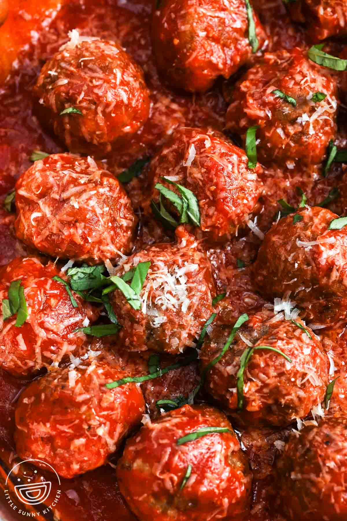 closeup view of soft ricotta meatballs in marinara sauce.