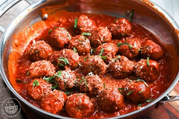 ricotta meatballs in marinara sauce, topped with grated parmesan cheese and basil.