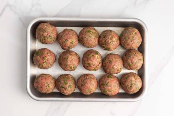 15 meatballs rolled smooth and placed on a parchment lined small baking pan.