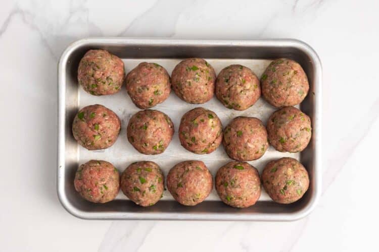 15 meatballs rolled smooth and placed on a parchment lined small baking pan.