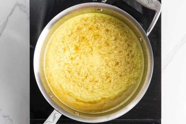 basmati rice cooking in water seasoned with bouillon and spices.