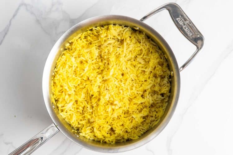 yellow turmeric rice in a saucepan.