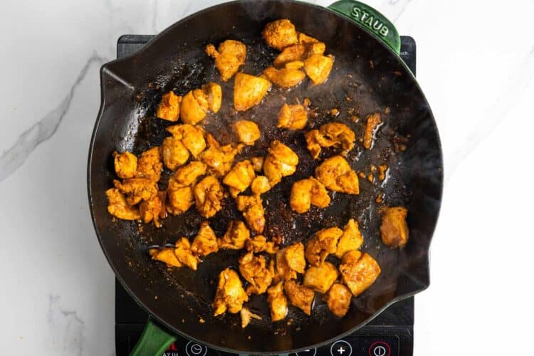 halal style chicken cooking in a heavy skillet.