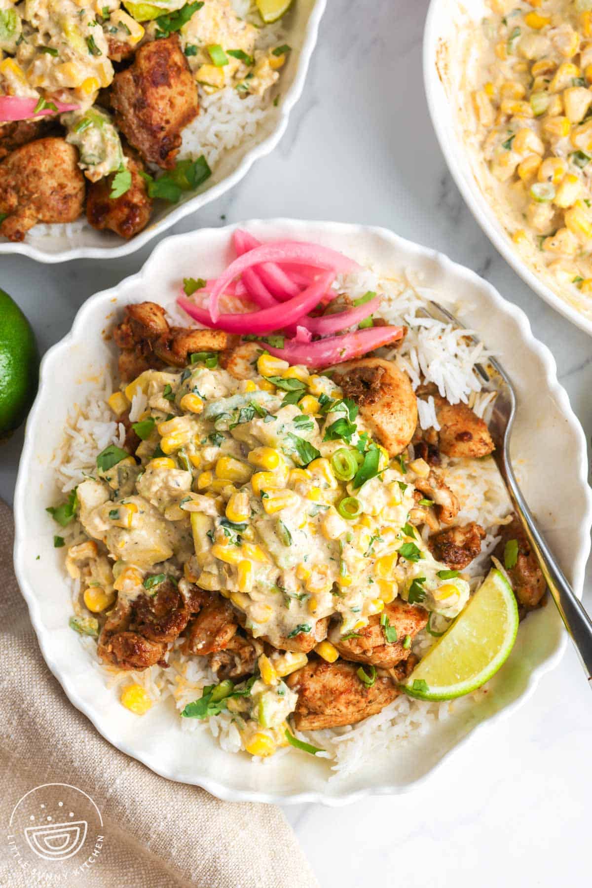a rice bowl topped with chicken and creamy street corn salad.