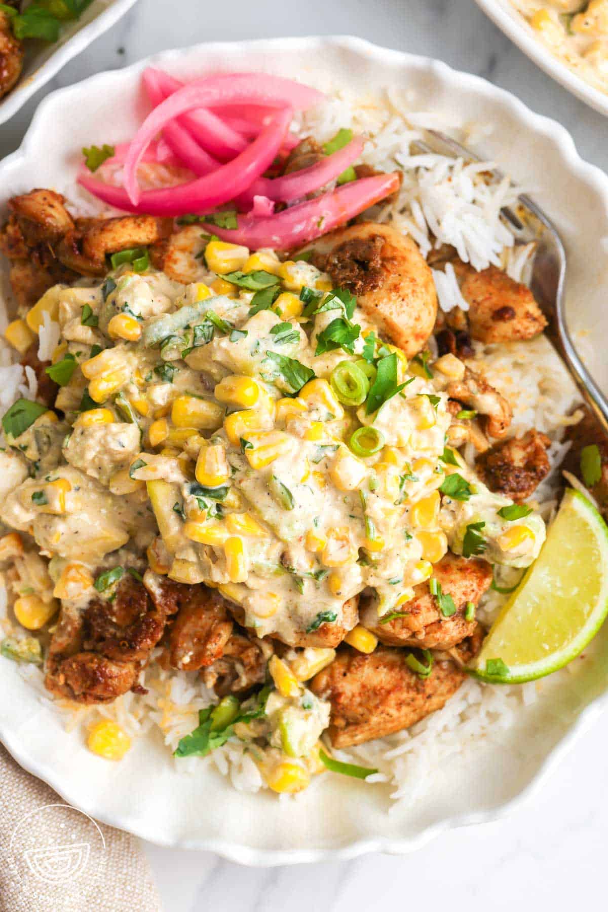 overhead view of a large portion Mexican corn chicken rice bowl with creamy street corn salad