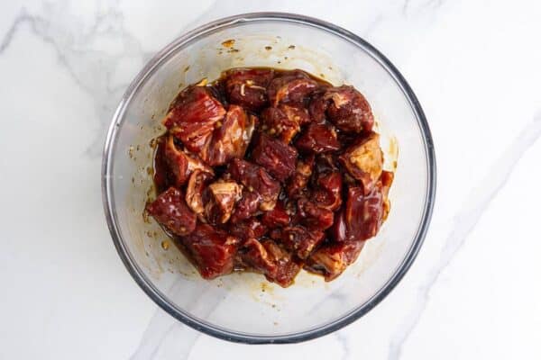cubes of steak marinating in a bowl for bo luc lac