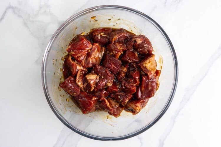 cubes of steak marinating in a bowl for bo luc lac