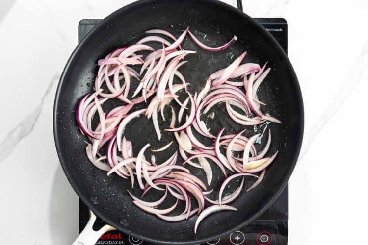sliced red onion sauteed in a skillet.