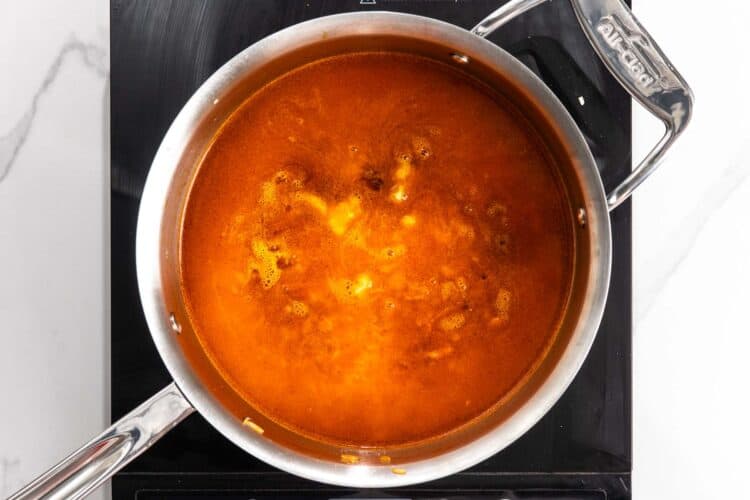 Rinsed jasmine rice being toasted in butter in a saucepan until the grains look glossy.