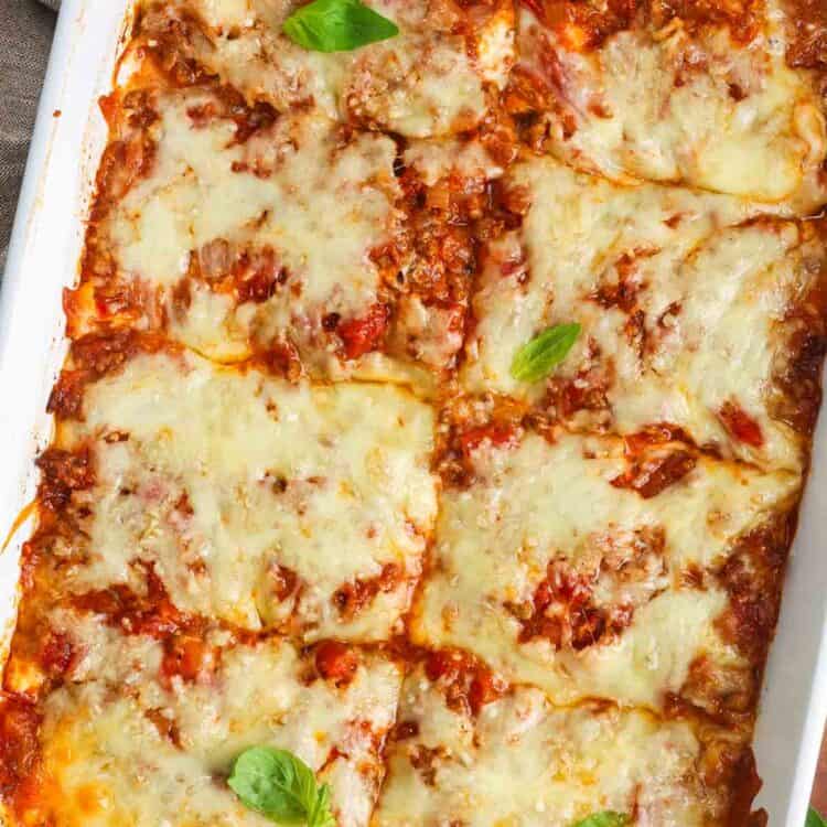 baked zucchini lasagna, cut into 8 squares and garnished with basil leaves.